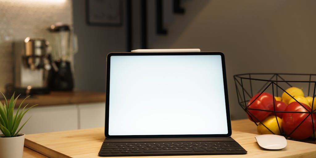 An overhead view of a desk with a laptop open to the Sales Loft pricing page, alongside a cup of coffee, a notepad with handwritten notes, and a smartphone displaying a sales dashboard. This composition suggests a busy sales professional evaluating options.