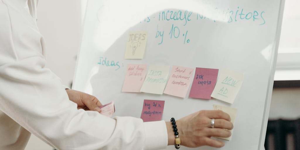 An overhead view of a brainstorming session where a diverse group of professionals is gathered around a table, discussing strategies while using Smartlead on their devices. Sticky notes and charts are scattered around, showcasing a collaborative environment.