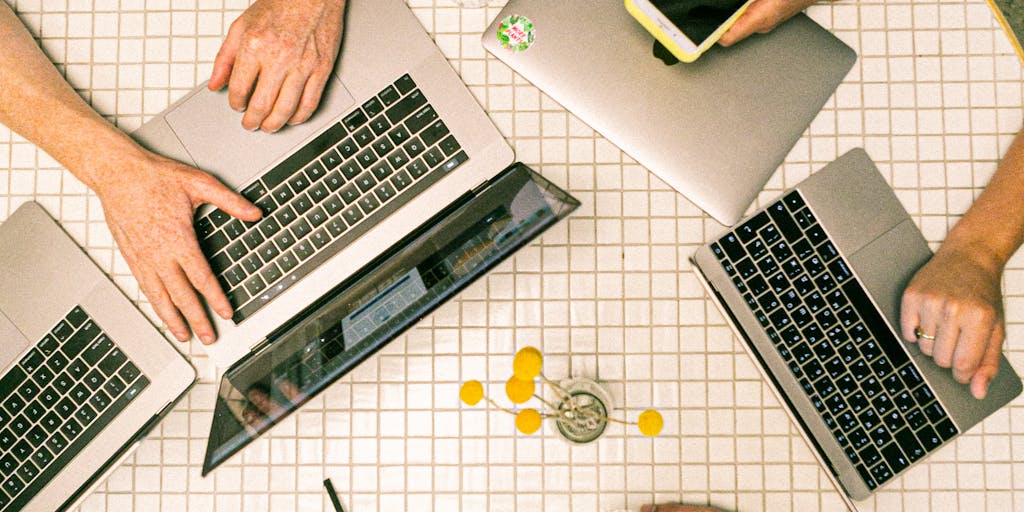 A group of diverse professionals gathered around a table, brainstorming and discussing strategies while looking at a large screen displaying a Lemlist campaign. The atmosphere is collaborative and energetic, highlighting teamwork in marketing.