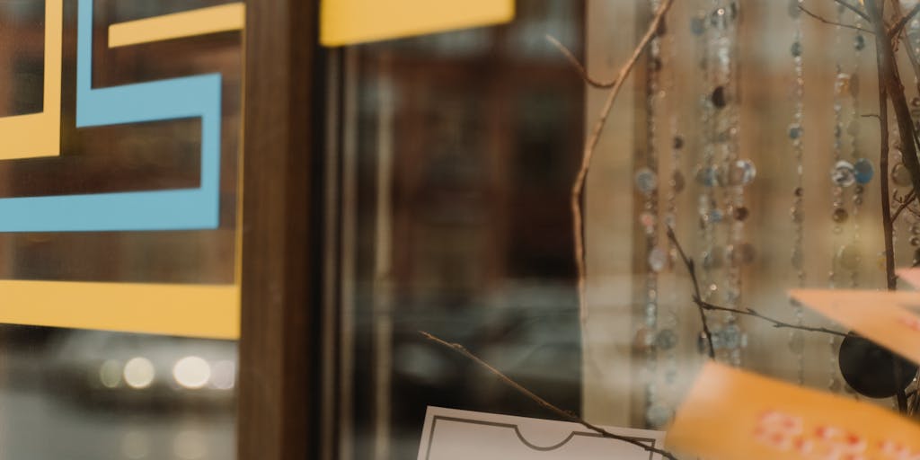 A creative composition featuring a hand holding a magnifying glass over a price tag, with a blurred background of shopping carts and products. This image conveys the idea of scrutinizing pricing details in a retail context.
