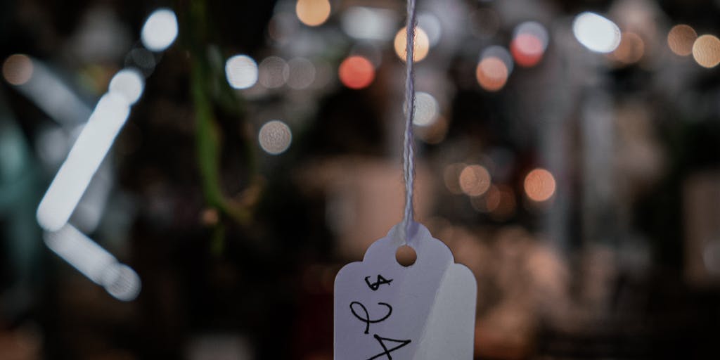 A serene landscape featuring a vast field of blooming lavender under a clear blue sky, with a vintage price tag hanging from a lavender plant. The tag displays the words 'Lavender AI Pricing' in elegant script, symbolizing the blend of nature and technology.