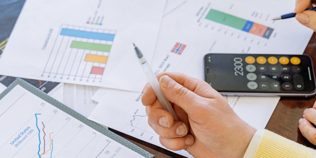 A close-up shot of a calculator with a hand pressing buttons, surrounded by colorful graphs and charts that represent pricing tiers. The background should be slightly blurred to emphasize the calculator and the financial data, symbolizing the analytical aspect of Buzzstream pricing.