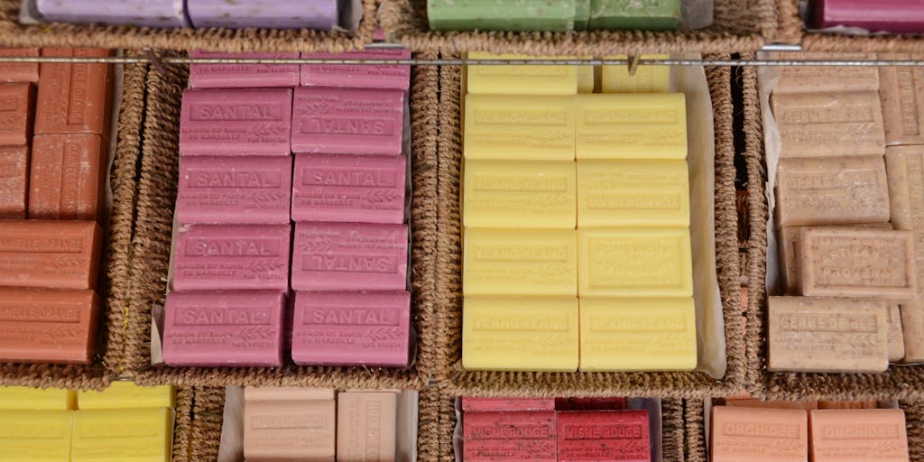 An overhead view of a market stall displaying various lavender products, such as sachets, essential oils, and dried lavender bundles. Each product has a small price tag attached, showcasing the concept of 'Lavender Pricing'. The vibrant purple hues of the lavender contrast with the natural wood of the stall.