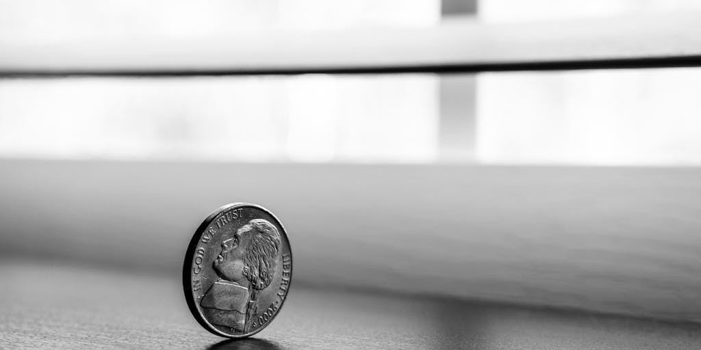 A conceptual image of a scale balancing two objects: a stack of coins on one side representing cost and a light bulb on the other side symbolizing ideas and value. This visual metaphor illustrates the balance between pricing and the value offered by Pitchbox.