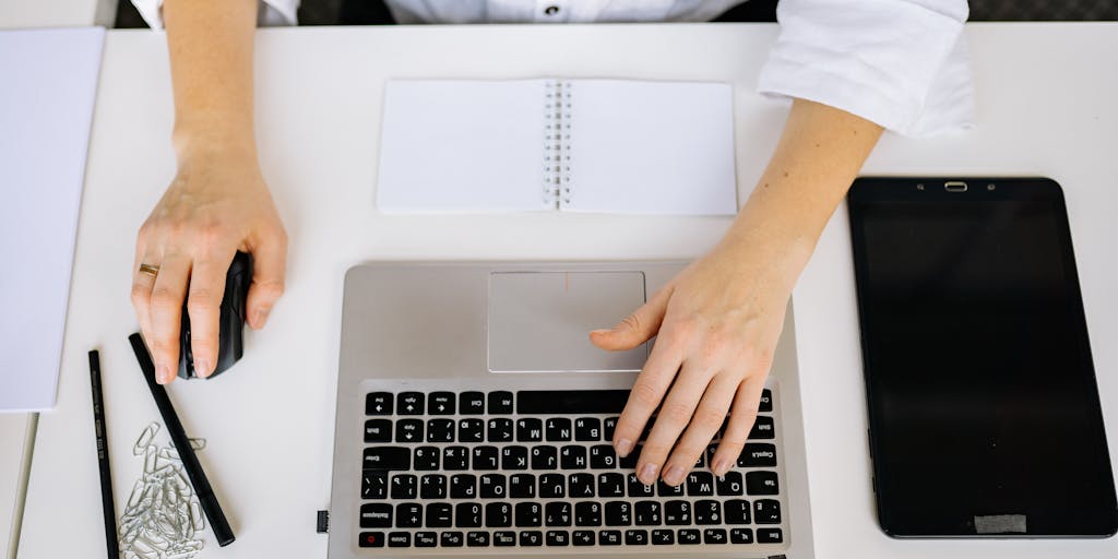 An overhead view of a desk with a calculator, a notepad, and a cup of coffee, with the Gmelius pricing page open on a tablet. The scene is styled with a minimalist aesthetic, featuring soft lighting and a clean layout to emphasize the financial aspect of choosing a pricing plan.