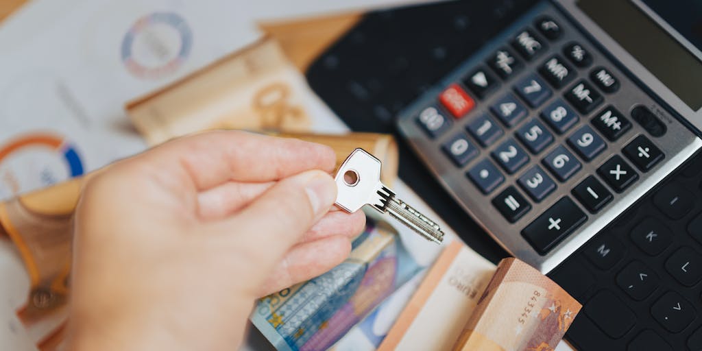 A creative flat lay of different currency notes and coins arranged in the shape of a pie chart, symbolizing the various pricing options of Anymailfinder. Include a small sign that says 'Invest in Your Email Strategy' to add context.