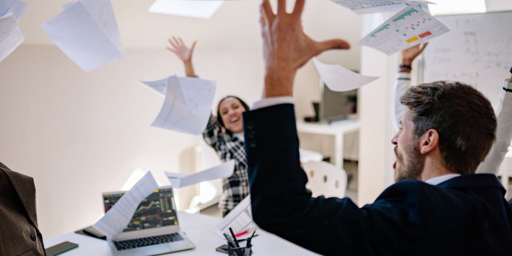 A dynamic image of a diverse team in a meeting, animatedly discussing sales engagement pricing strategies. Capture expressions of enthusiasm and collaboration, with charts and graphs projected on a screen in the background.