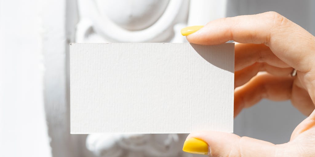 A creative flat lay of various Adobe Marketo pricing plans represented as colorful cards or infographics, arranged in a visually appealing manner on a wooden table. Include elements like a pen, a laptop, and a plant to add a touch of creativity and life.