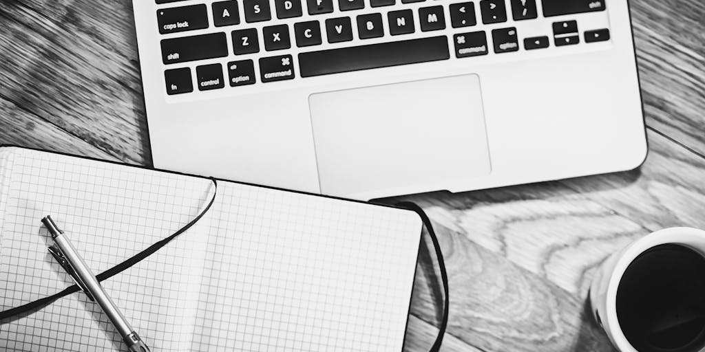 An overhead view of a desk with a laptop open to a Leadiq pricing page, alongside a cup of coffee, a notepad with brainstorming ideas, and a smartphone displaying a graph of sales growth. This composition highlights the integration of technology and strategy in pricing decisions.