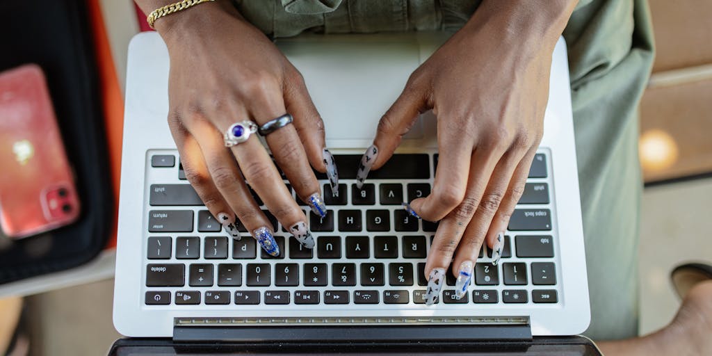An overhead view of a modern workspace featuring a laptop displaying the Crystalknows Pricing interface, surrounded by colorful gemstones and crystals. The gemstones should represent different pricing tiers, with labels indicating their value, creating a vibrant and engaging visual.