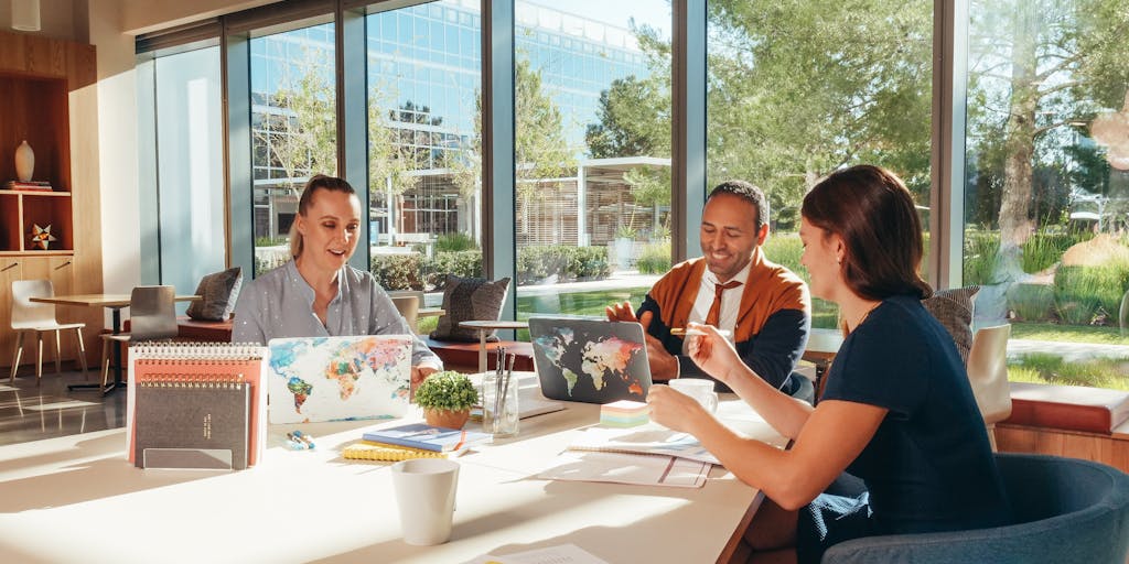 An overhead view of a diverse group of people sitting in a circle, each with a laptop open in front of them. Above each laptop, there are floating price tags representing different outreach pricing options, showcasing collaboration and engagement.