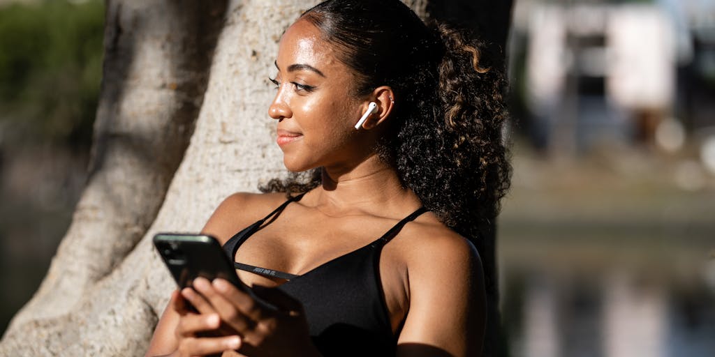 A dynamic image of a person walking in a city while listening to a podcast on their smartphone. The background should feature urban elements like buildings and street art, capturing the essence of modern digital marketing in a fast-paced environment.