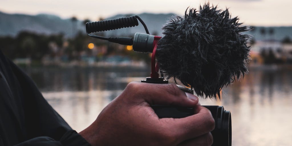 A close-up shot of a microphone with sound waves visually represented around it, symbolizing the impact of podcasts in digital marketing. The background should be blurred to emphasize the microphone, with hints of digital marketing elements like graphs or social media icons subtly integrated.