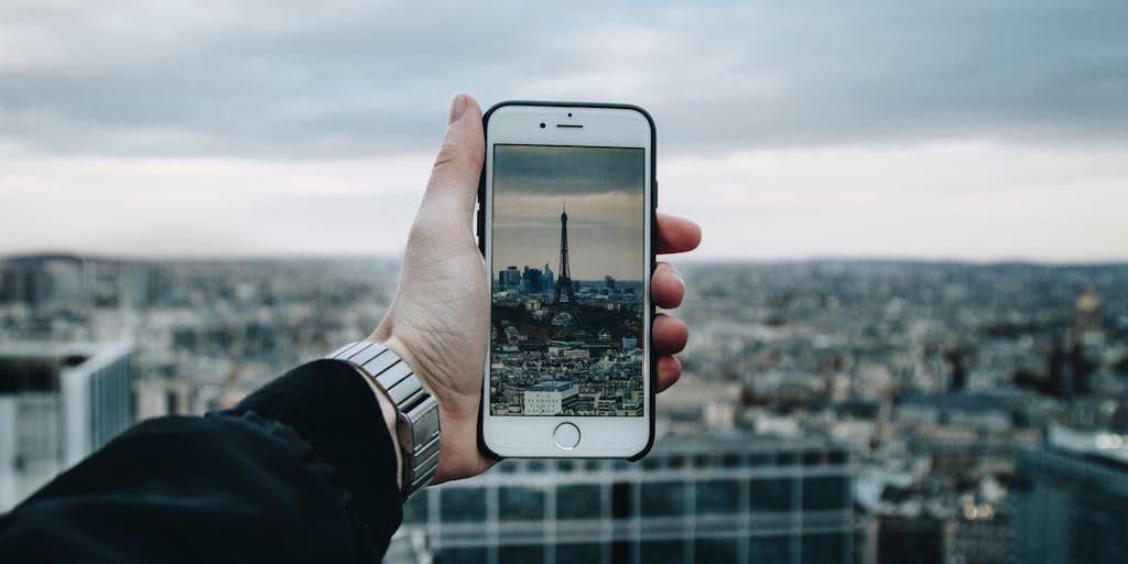A close-up shot of a person holding a smartphone displaying the Amazon app, with a backdrop of a bustling cityscape. The image captures the essence of mobile commerce and the importance of digital marketing in reaching consumers on-the-go.