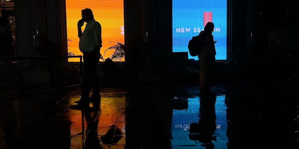 An eye-catching billboard in an urban setting displaying a mobile ad campaign. The photo should capture the billboard illuminated at night, with people interacting with their smartphones, highlighting the impact of mobile advertising in real-world scenarios.