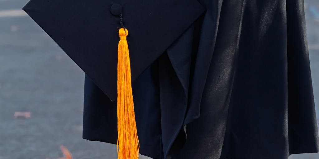 An artistic representation of a gavel and a graduation cap on a table, symbolizing the legal aspects of child support and the transition to adulthood. The background could include blurred images of a family, emphasizing the emotional impact of this change.