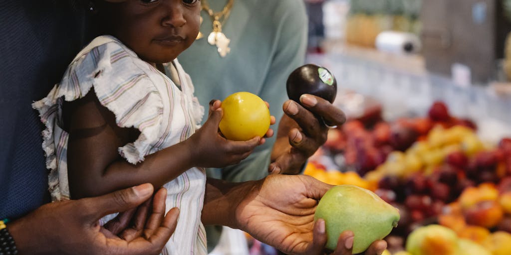 A candid moment of a parent and child shopping for groceries together, with a shopping cart filled with healthy food options. This scene captures the everyday expenses that child support helps to cover, emphasizing the importance of nutrition in a child's development.