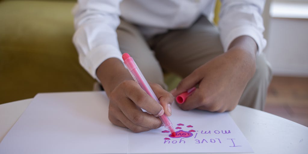 A heartwarming photo of a child holding a handmade 'Thank You' card, with a parent in the background smiling. This image captures the positive outcomes of child support, emphasizing the importance of financial support in providing for a child's needs and happiness.