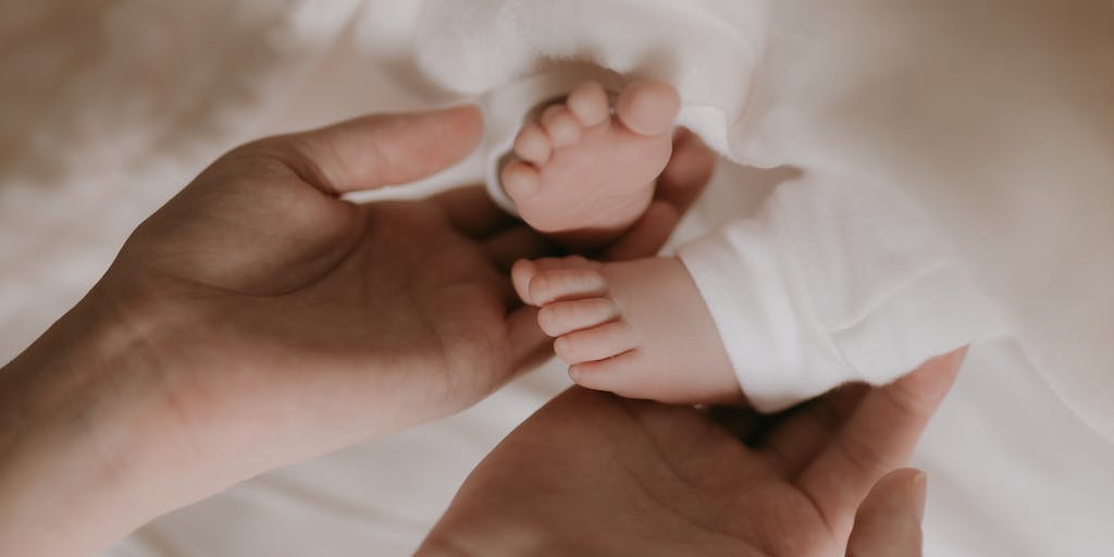 An artistic representation of two hands, one from each parent, reaching towards a child playing in the center. The hands are holding symbolic items like a piggy bank and a toy, illustrating the financial and emotional support both parents provide, even in a 50/50 custody situation.