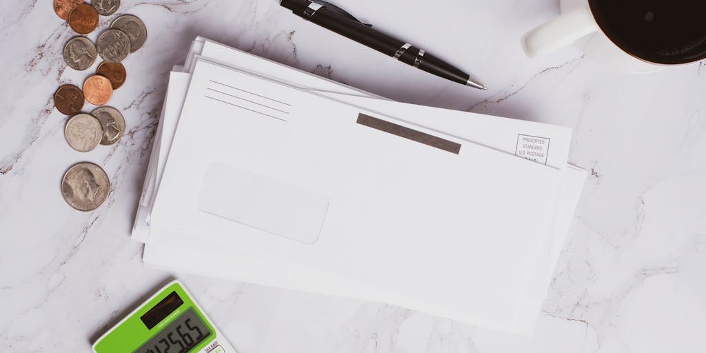 A close-up shot of a college acceptance letter with a child's hand holding it, alongside a calculator and a stack of bills, representing the financial responsibilities of child support during college years.