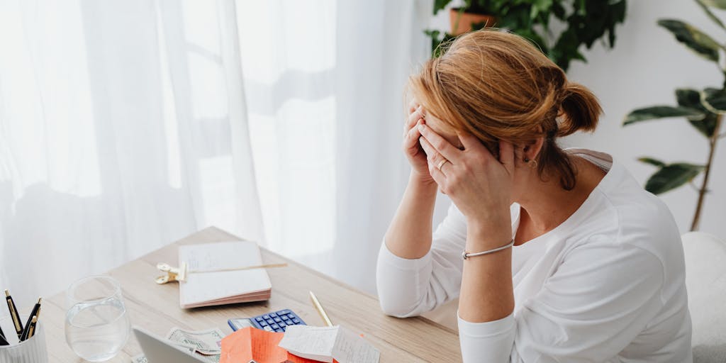 A split image showing a parent on one side calculating expenses with a calculator and bills spread out on a table, while on the other side, a child is happily playing with toys. This juxtaposition highlights the financial responsibilities of child support versus the joy of parenting.