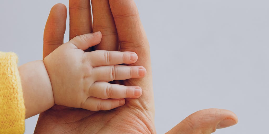 A split image showing two scenarios: on one side, a parent happily playing with their child in a park, and on the other side, the same parent looking stressed while reviewing child support paperwork at home. This juxtaposition highlights the emotional impact of child support.