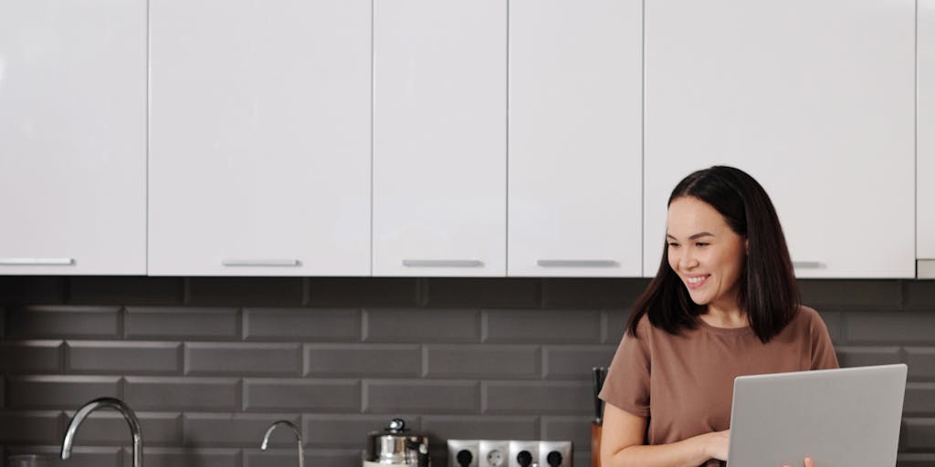 An image of a parent sitting at a kitchen table with a laptop open, looking relieved while reviewing a checklist titled 'Steps to Terminate Child Support'. The scene conveys a sense of empowerment and organization in navigating the legal process.