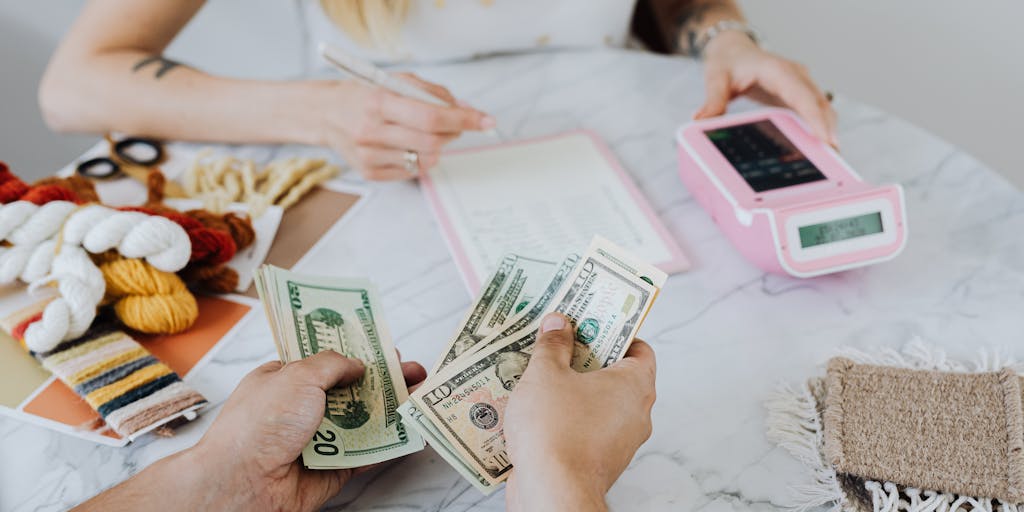 An overhead view of a dining table with a variety of bills, including a SNAP application form and a child support payment receipt. A cup of coffee sits beside the papers, suggesting a moment of contemplation about financial responsibilities.