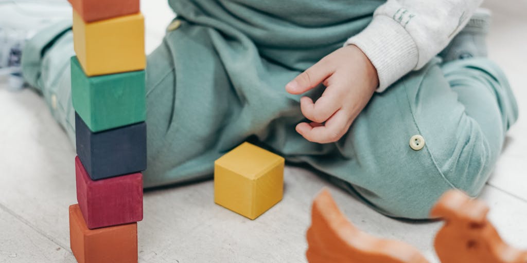 A conceptual photo of a scale balancing a stack of bills on one side and a child's toy on the other, symbolizing the balance between financial obligations and the needs of a child. The background can be a soft-focus image of a home environment.