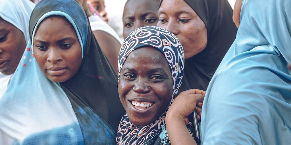 A photo of a community support group meeting in a cozy room, with mothers sharing their experiences about child support. The image should capture the warmth of community and support, with a focus on diverse women engaged in conversation.