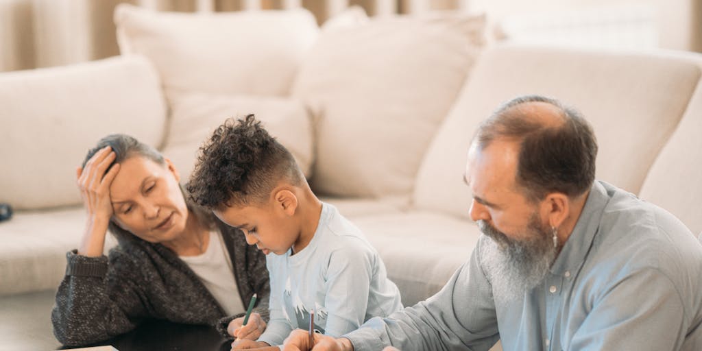 A close-up shot of a grandparent's hands holding a child's drawing, with a blurred background of legal documents and a gavel, representing the intersection of family love and legal responsibilities regarding child support.