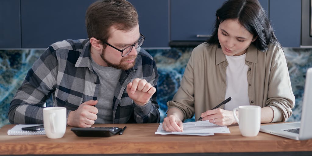 A split image showing a couple sitting at a dining table, one side depicting a happy family dinner, while the other side shows a tense discussion about finances. The contrast highlights the complexities of marriage and financial responsibilities.