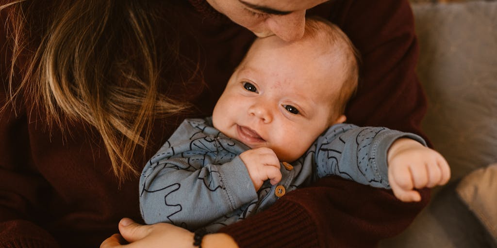 A close-up shot of a mother holding her child while looking thoughtfully at a calendar marked with important dates, such as court dates or financial meetings. This image captures the emotional weight of decisions regarding child support.