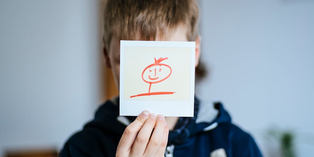 A close-up shot of a hand holding a VA disability card, with a child’s drawing in the background. This image conveys the connection between financial support and the well-being of a child, emphasizing the importance of understanding income sources.