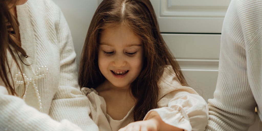 A close-up shot of a person holding a stack of unpaid bills and a child support payment notice, with a worried expression. The background features a calendar marked with important dates related to child support payments.