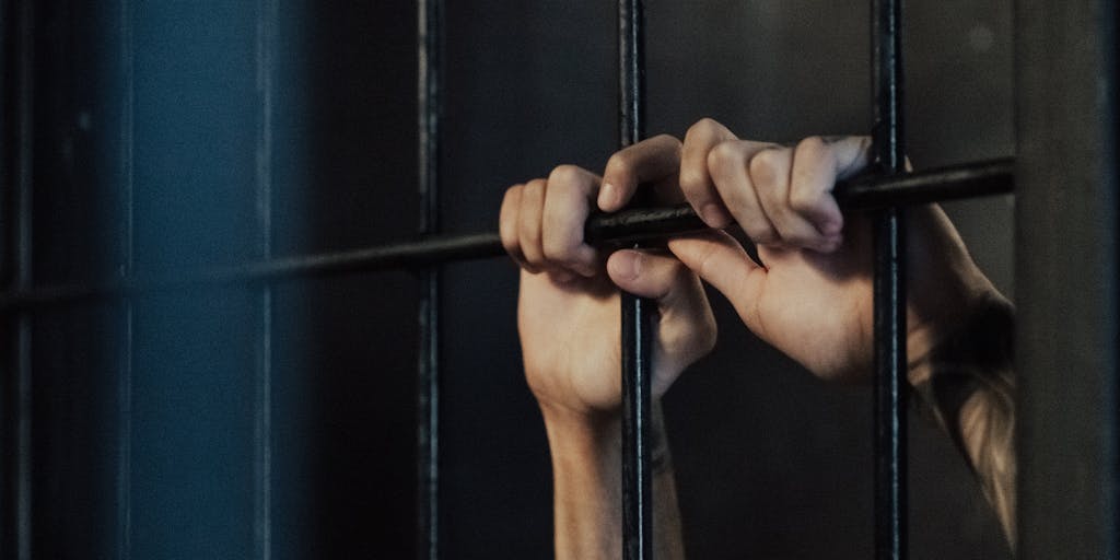 A conceptual image of a scale balancing a stack of money on one side and a prison cell on the other. This visual metaphor represents the potential felony charges for failing to pay child support in Mississippi, illustrating the weight of financial responsibilities.