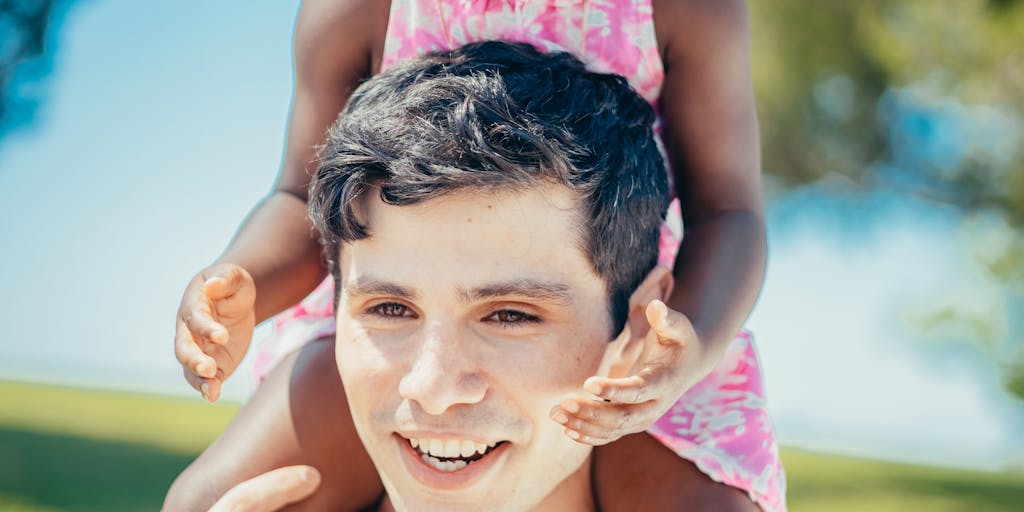 A split image showing a father sitting at a table with a stack of bills on one side and a joyful scene of him playing with his child in a park on the other. The contrast highlights the emotional and financial aspects of child support and visitation rights.