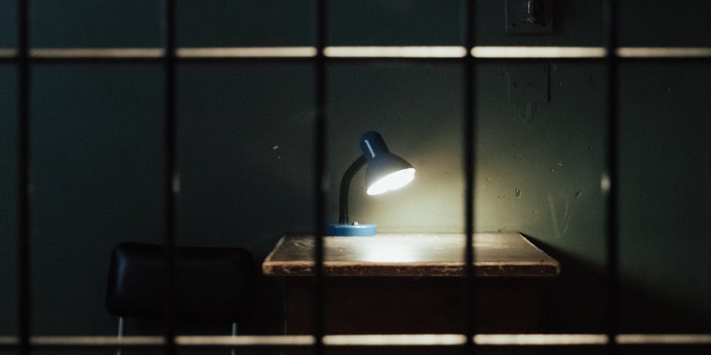 A conceptual photo of a child holding a piggy bank, looking up with a hopeful expression, while a shadow of a father in prison bars looms in the background. This image conveys the innocence of the child and the burden of financial support that falls on the remaining parent.