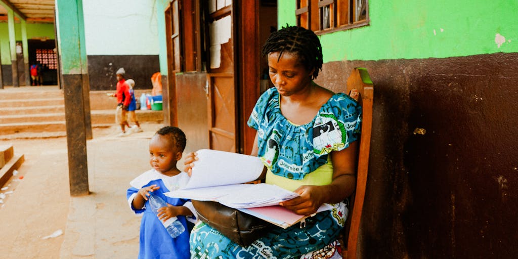 A candid photo of a parent and child engaging in a fun activity, like baking or playing a game, with a subtle background of financial documents and a laptop open to a child support calculator. This image conveys the message that despite financial challenges, the bond between parent and child remains strong.