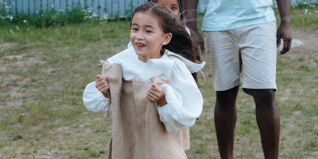 An outdoor scene featuring a child participating in a sports activity, such as soccer or swimming, with a parent cheering from the sidelines. This image illustrates how child support can be used for extracurricular activities that promote physical health and social skills.
