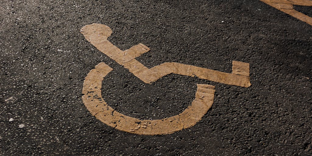 A conceptual image of a road sign with two arrows: one pointing towards 'Independence' and the other towards 'Support'. The background features a sunset, symbolizing the end of a journey and the beginning of a new chapter in life.
