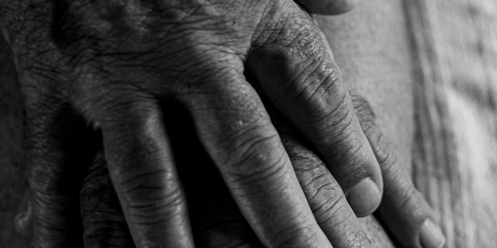 A close-up shot of a child’s hands holding a piece of paper with the words 'Joint Custody' written on it, while the background shows blurred images of both parents smiling in separate frames. This symbolizes the emotional aspect of joint custody and the importance of support.