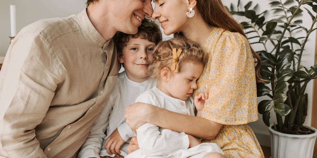 A cozy living room scene where a couple is sitting together on a couch, surrounded by children's toys and books. The woman is looking thoughtfully at a legal document, while the man is playfully engaging with a child. This image captures the complexity of living together while navigating child support issues.
