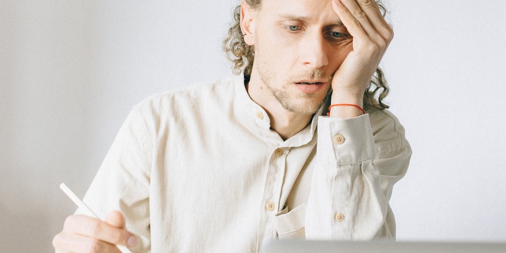 A close-up shot of a person holding a stack of paperwork with a frustrated expression, surrounded by a clock and a calendar. This image captures the stress and anticipation involved in waiting for child support decisions.