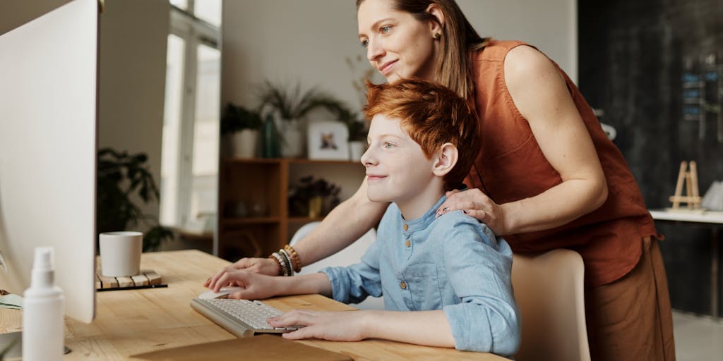 A cozy study area with a child doing homework at a desk filled with school supplies, while a parent assists them with a smile. This image represents the investment of child support in education and the importance of parental involvement in a child's academic success.