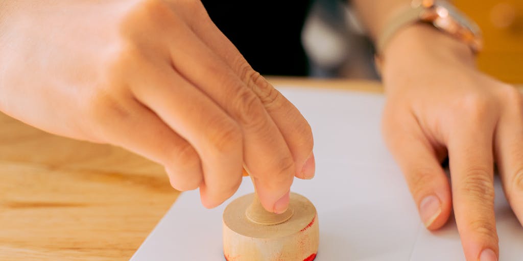 A close-up shot of a hand holding a 'Paid in Full' stamp over a child support document, with a blurred background of a family celebrating together. This image captures the moment of financial relief and the positive impact on family dynamics.