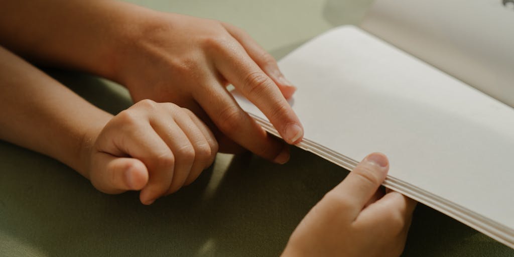 A close-up shot of a child holding two hands, one from each parent, symbolizing support and love. The background is softly blurred to emphasize the hands, which are intertwined, showcasing unity despite separation. The focus is on the child's expression of comfort and security.