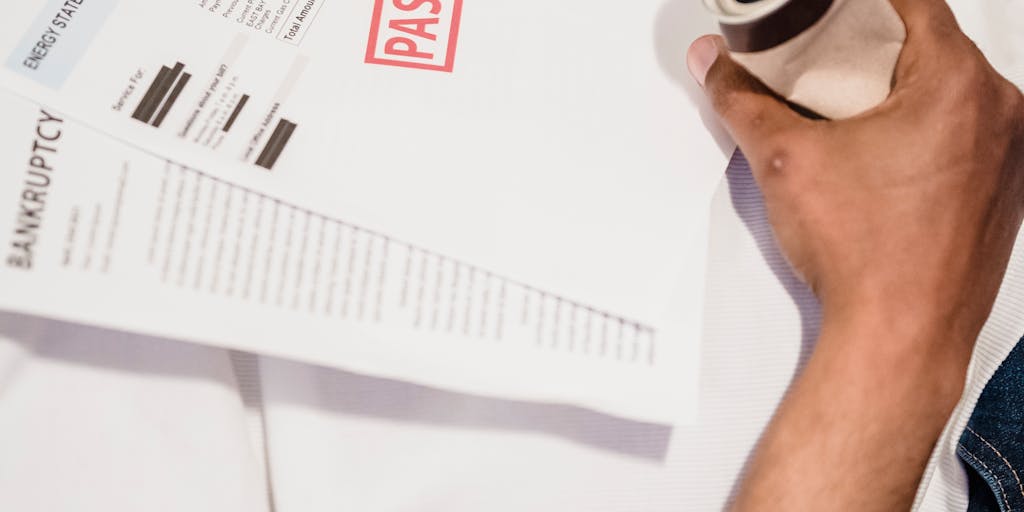 An image of a piggy bank with a sad face drawn on it, sitting on a table surrounded by bills and a laptop displaying a 'payment overdue' notification. This visual metaphor represents the financial strain and concern over late child support payments.