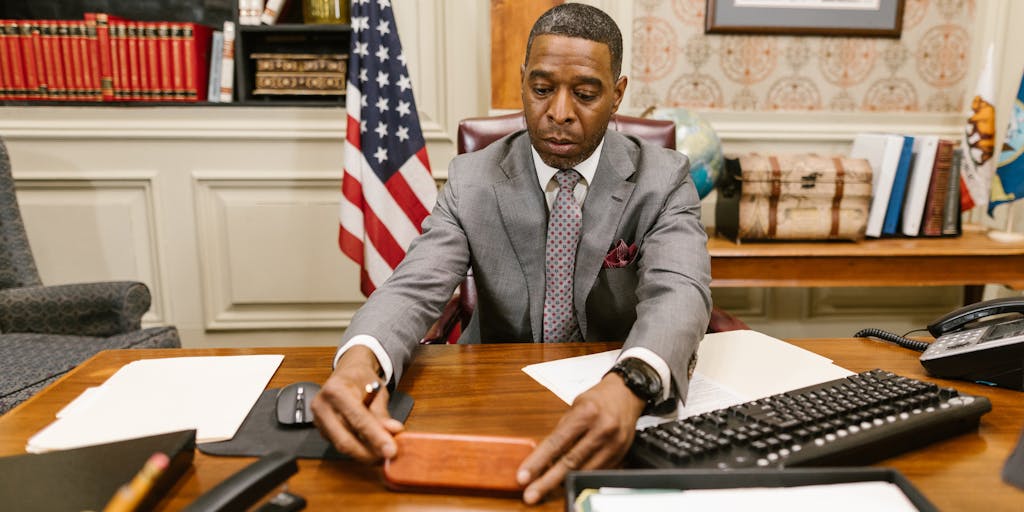 A candid shot of a family law attorney discussing child support with a client in an office setting. The attorney is pointing to a document while the client takes notes, emphasizing the importance of legal guidance in understanding child support.