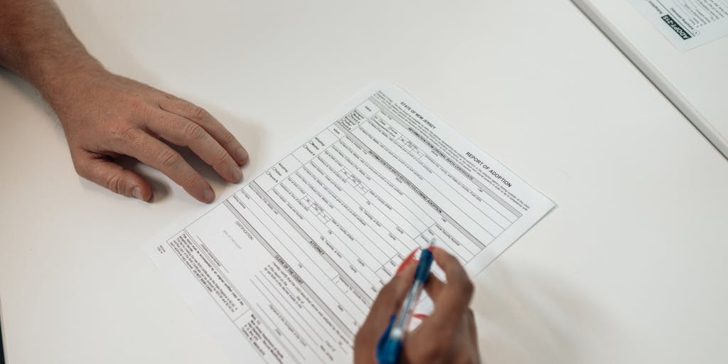 A close-up shot of a parent and child sitting at a table, reviewing a child support agreement together. The focus is on their hands pointing at the document, with expressions of concern and understanding. This captures the collaborative aspect of determining child support.